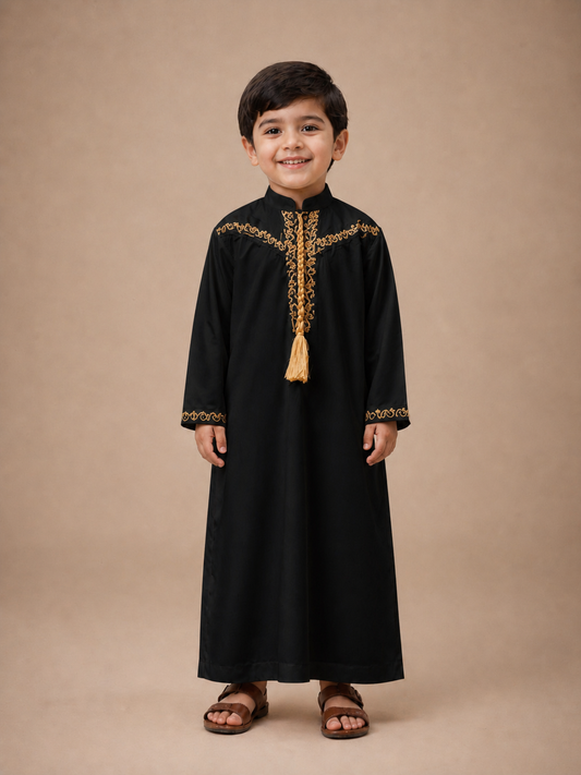 Child wearing a white Thobe Jubba traditional outfit with gold embroidery on a beige background